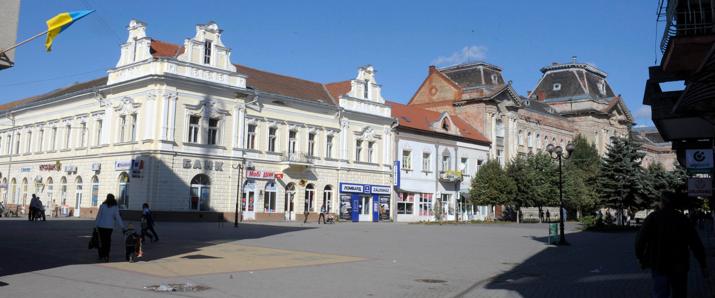A Kárpátaljai Magyar Főiskola - az egykori Törvényszék, később laktanya, majd műszergyár - épülete (jobbról) az ukrajnai Beregszászon, a Kossuth téren.