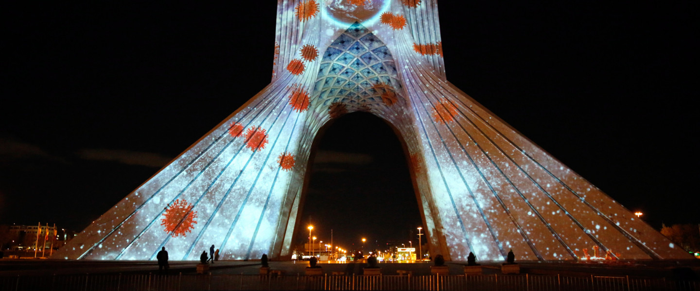 Koronavírus tematikájú fotókat vetítenek a teheráni Azadi (Szabadság) tér szobrára 2020. március 31-én.